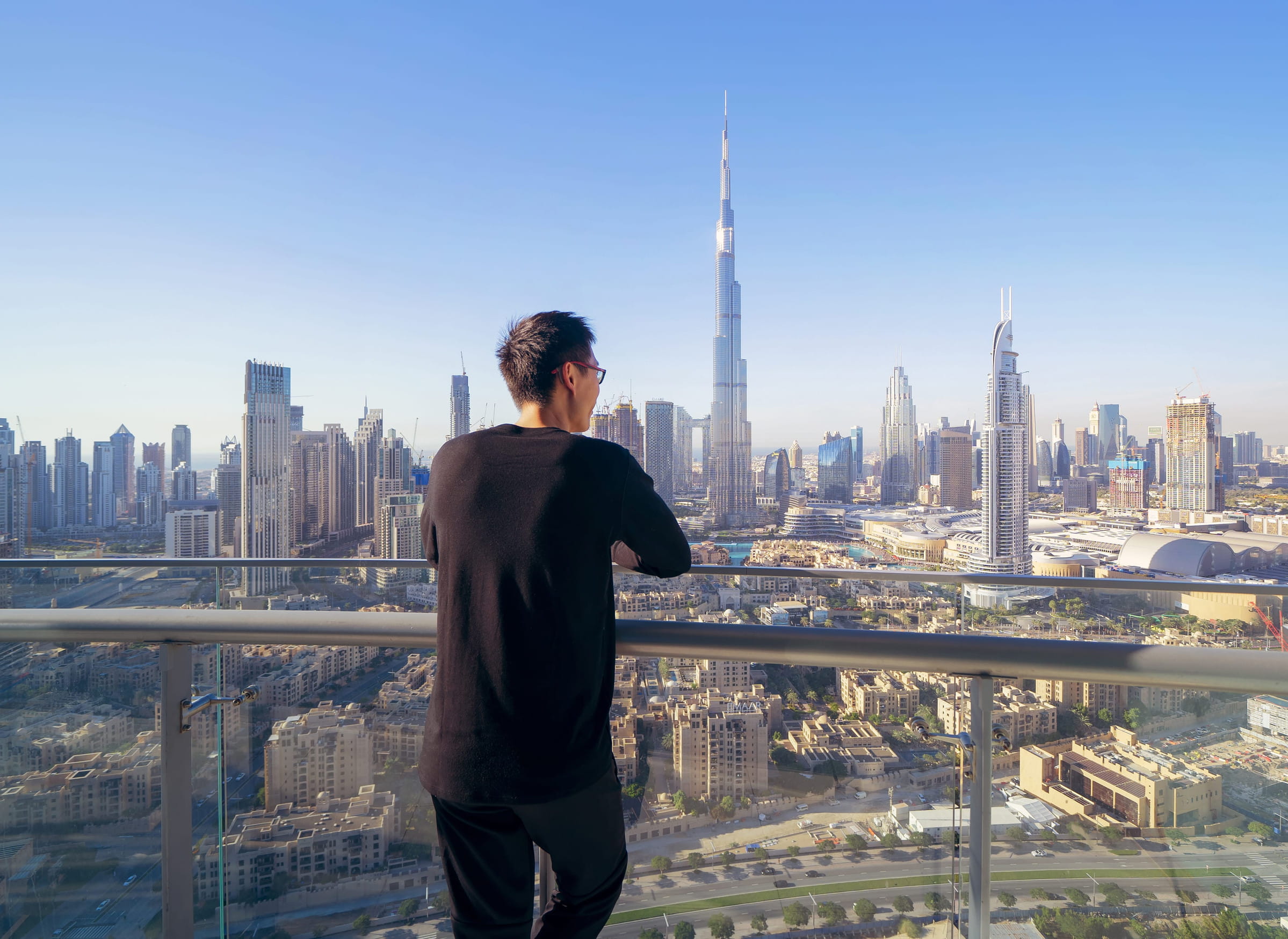 A Man Posing For A Shot With Burj Khalifa In The Background