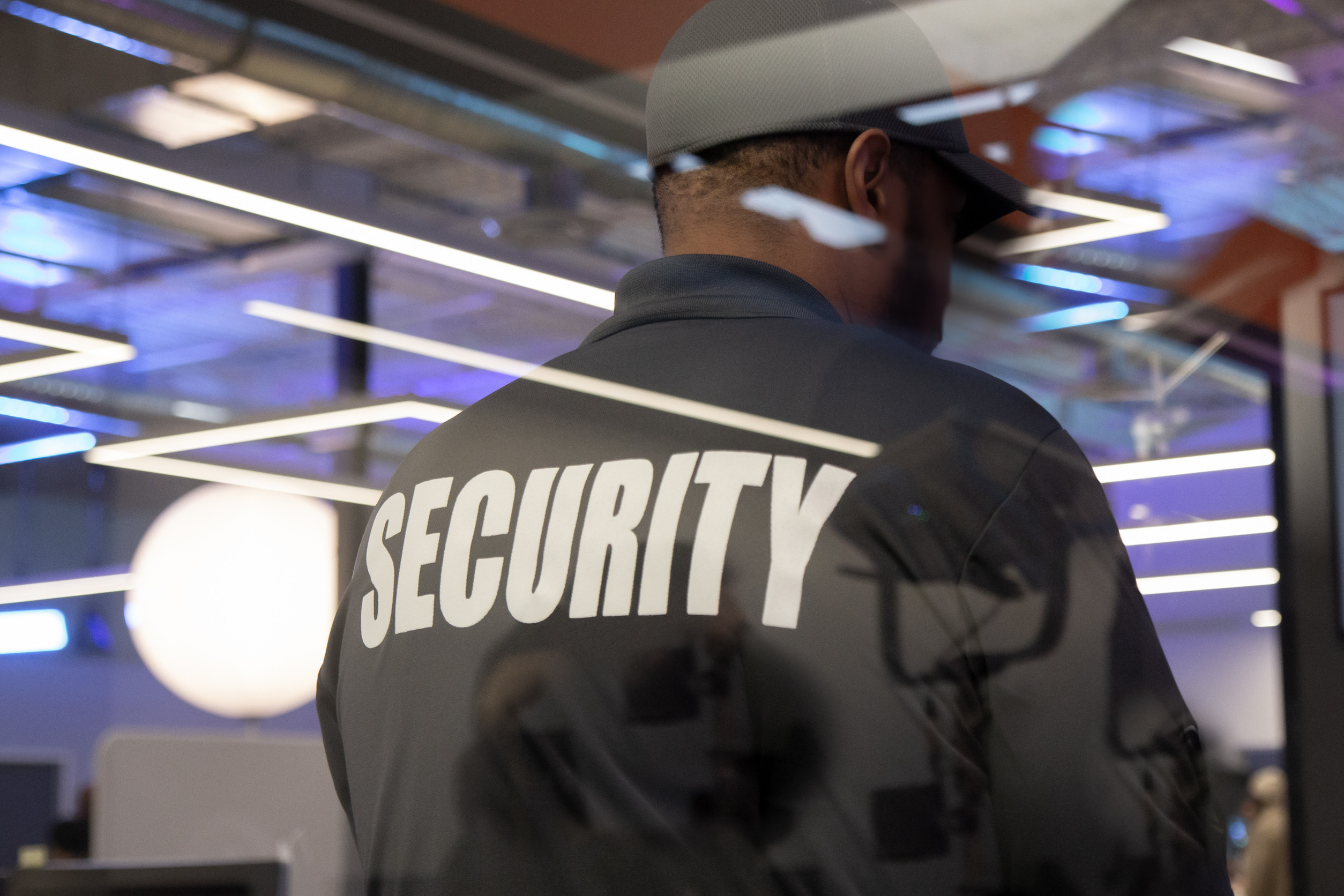 A Security Guard Standing Inside A Commercial Building
