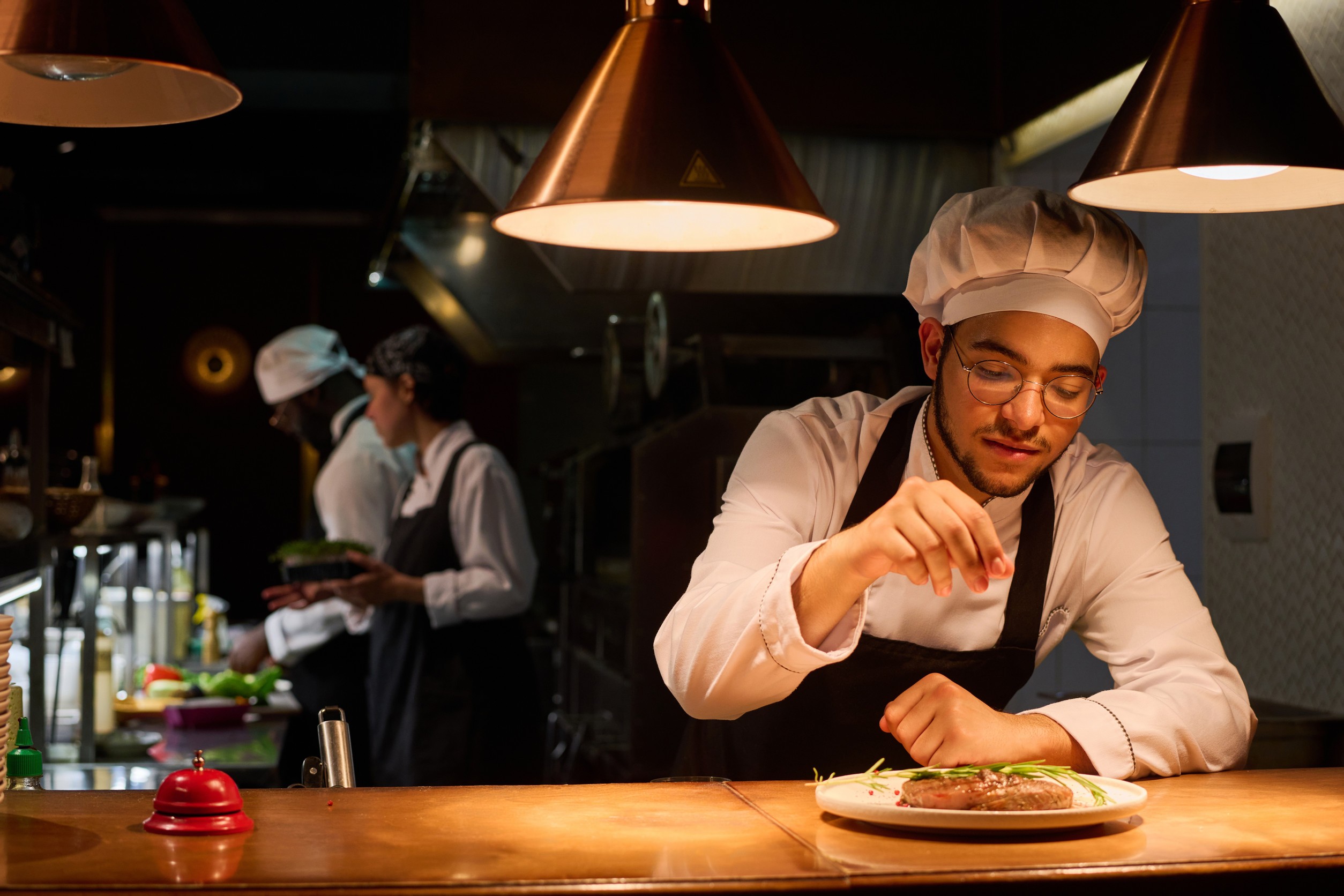 A Young Male Chef Garnishing Fried Meat